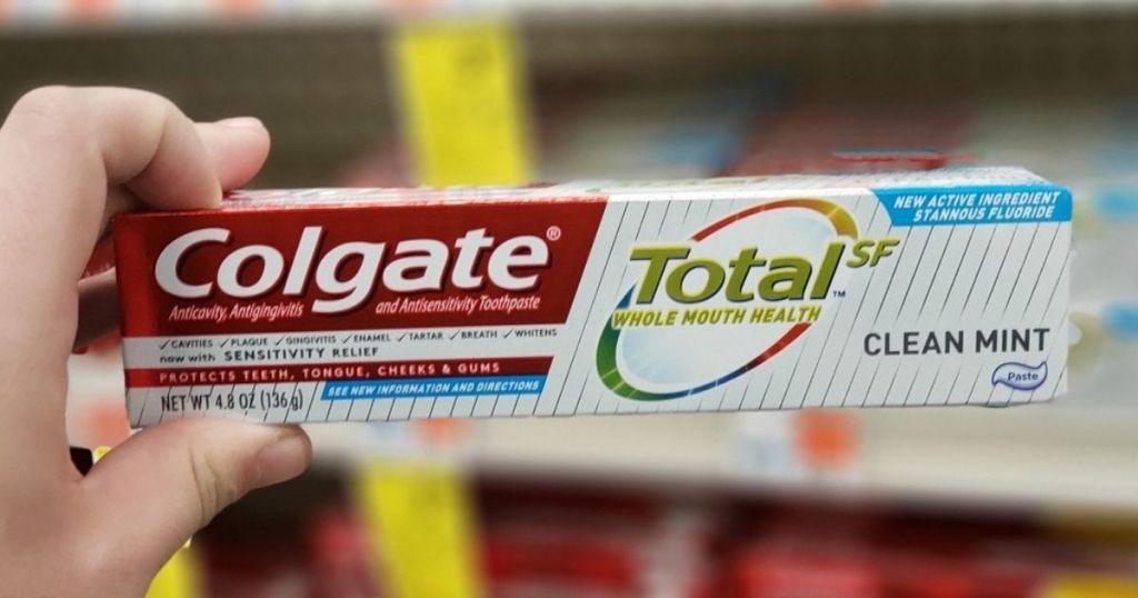 hand holding box of Colgate Total SF Toothpaste