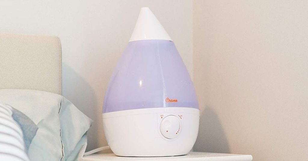 humidifier sitting next to a bed