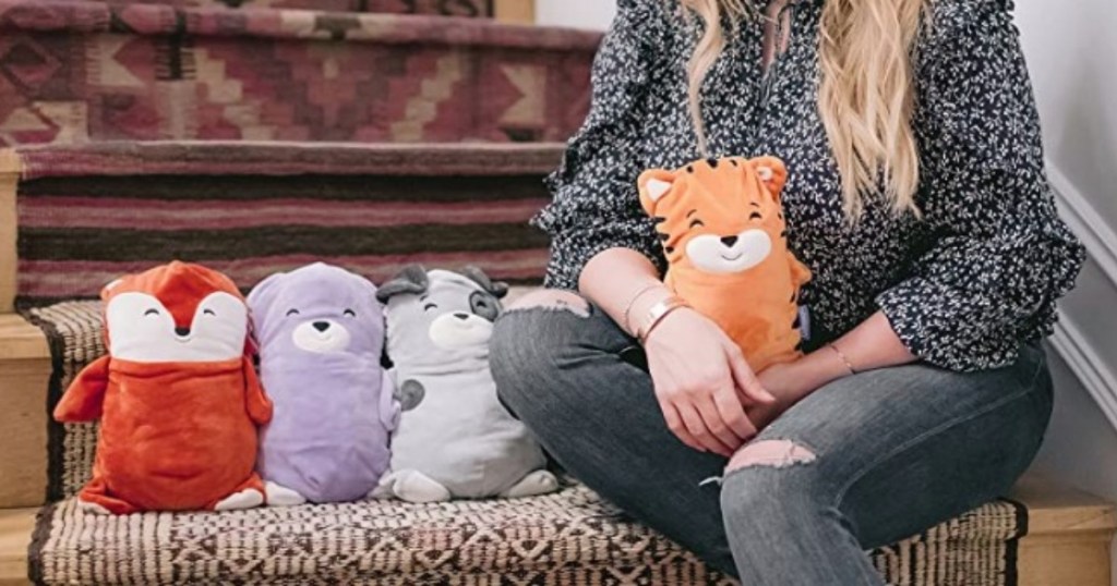 Lady sitting on stairs with cubcoats as plushies