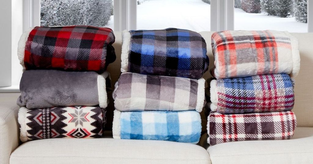pile of multiple patterned Cuddl Duds Oversized Throw With A Cozy Sherpa Pocket