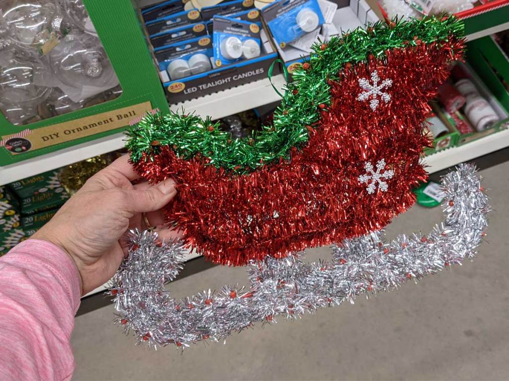 hand holding sleigh tinsel decoration