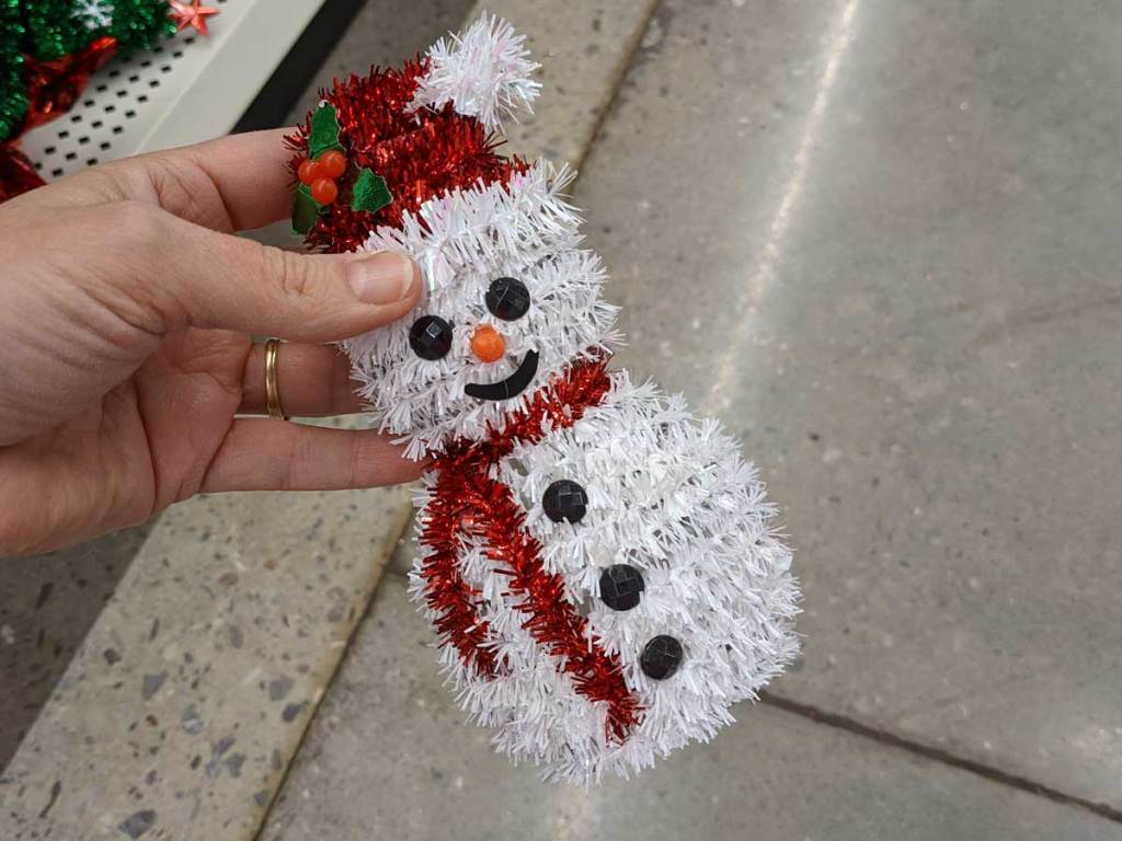 hand holding snowman tinsel decoration