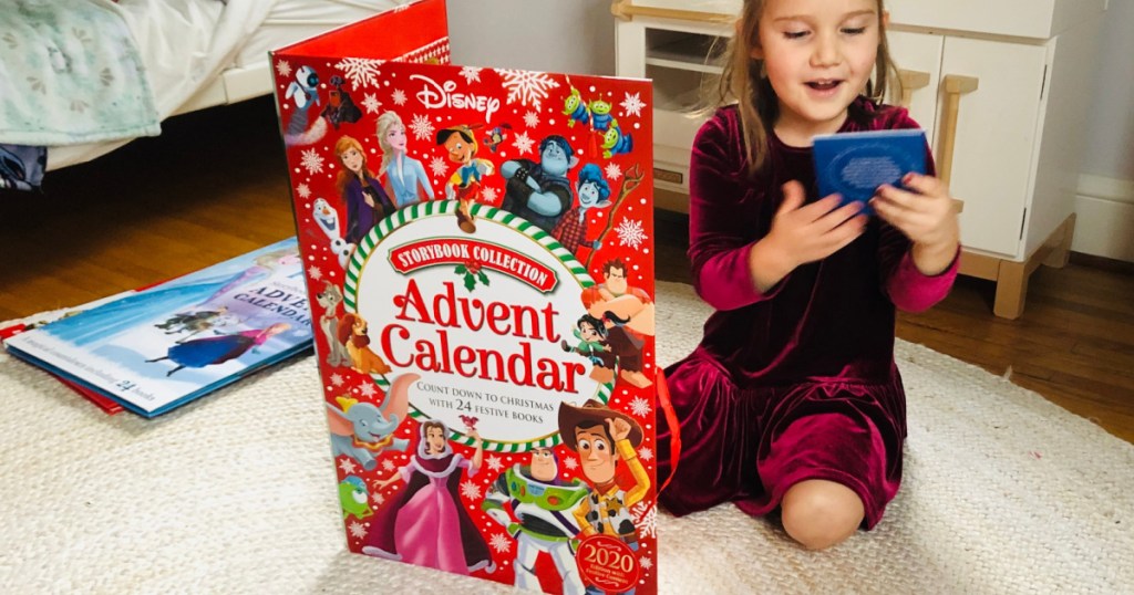 girl on bedroom floor with large storybook advent calendar