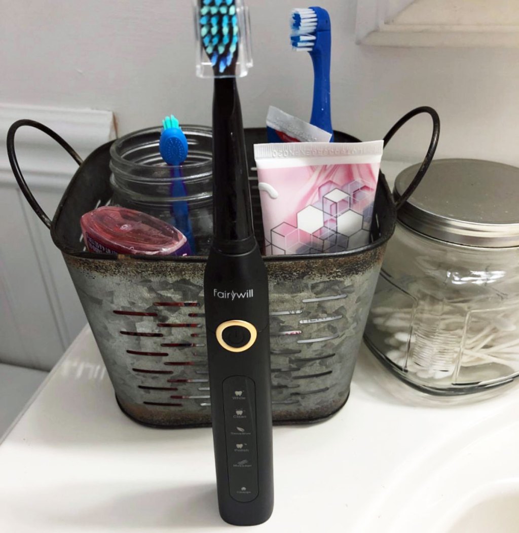 black electric toothbrush sitting on white bathroom counter