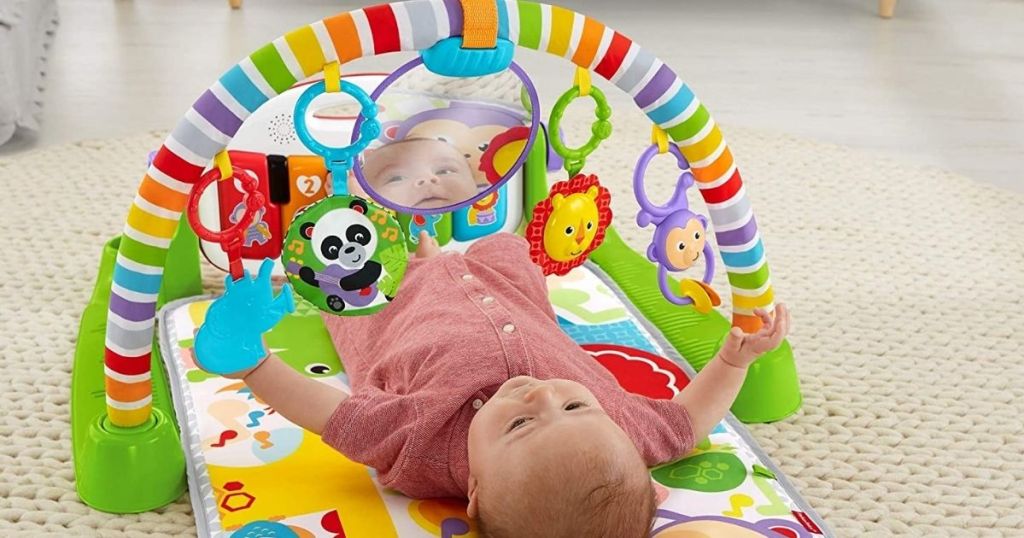 Baby laying on Fisher Price kick and play piano toy