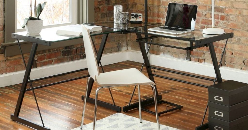 l-shaped desk with glass top and black legs in home office
