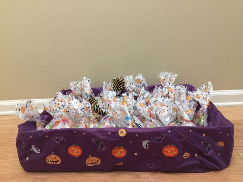 box covered with purple tissue paper, Halloween stickers and filled with festive goodie bags