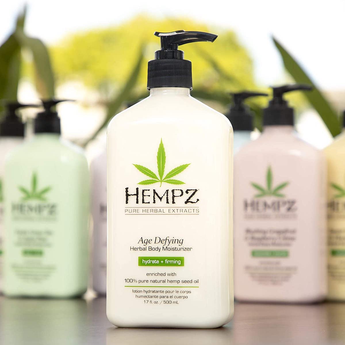 hempz body lotion pump bottles in front of blurred out foliage