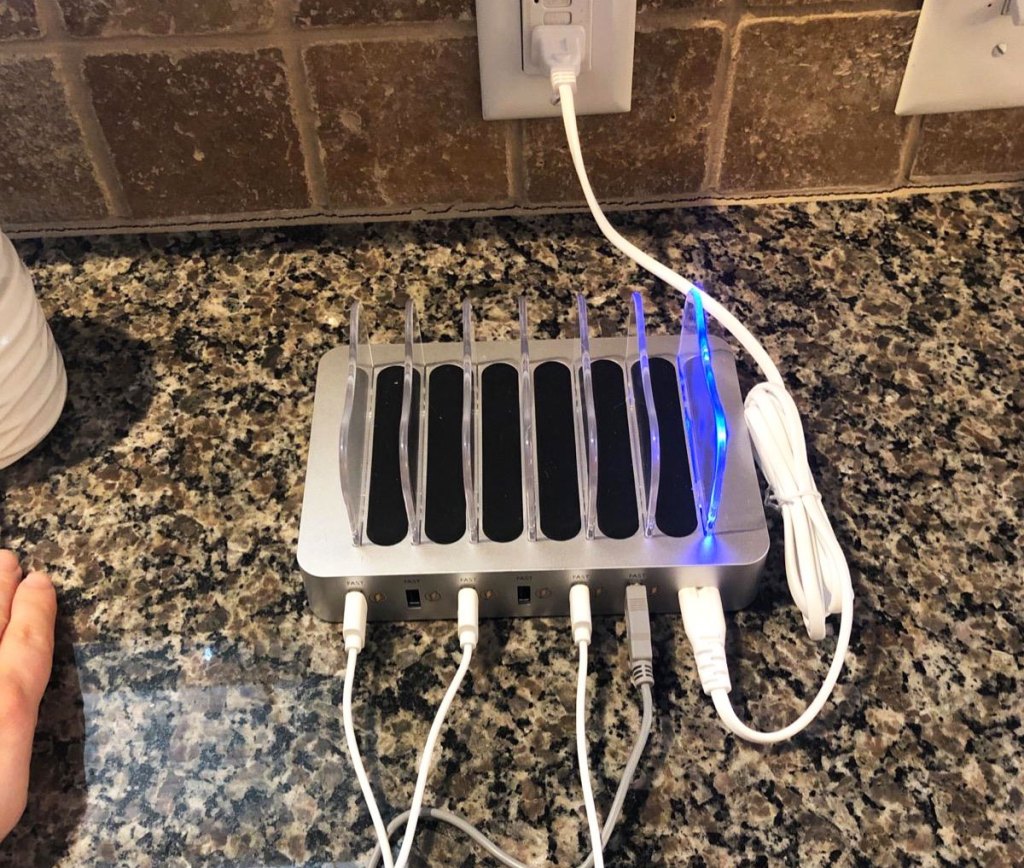 silver and black device charging station on kitchen counter plugged into electrical outlet