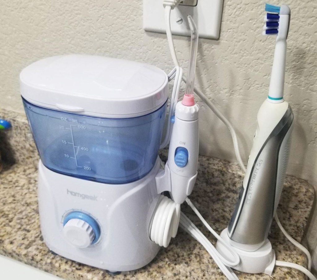 white and blue water flosser on bathroom counter next to electric toothbrush