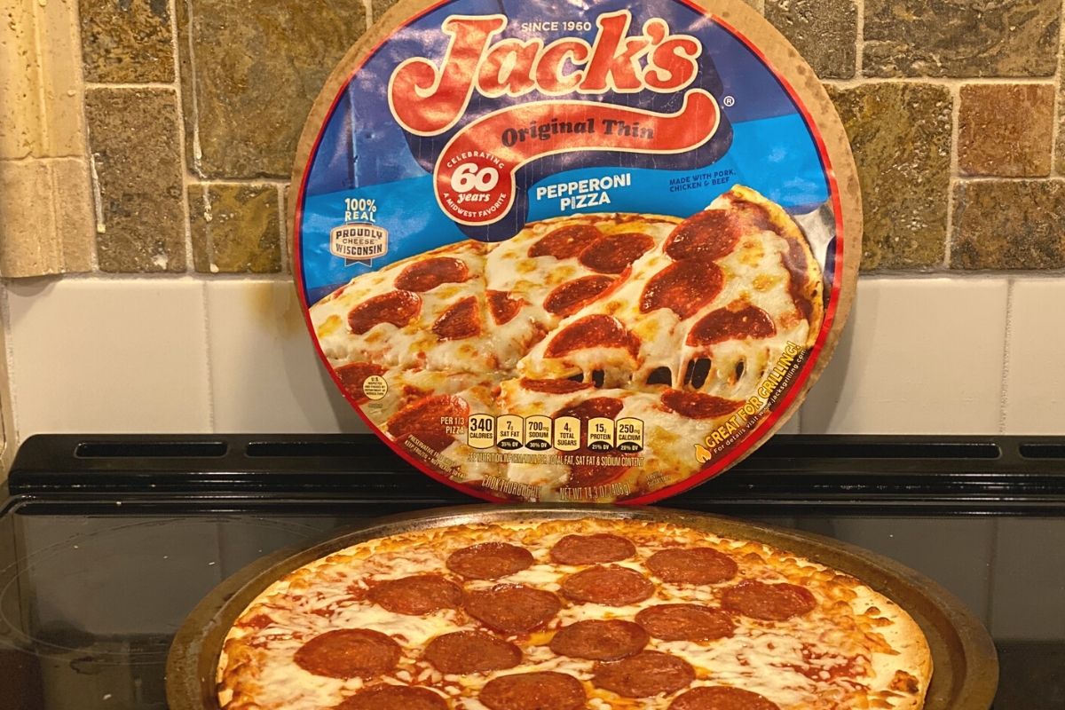 jack's pizza next to the original package on a stove