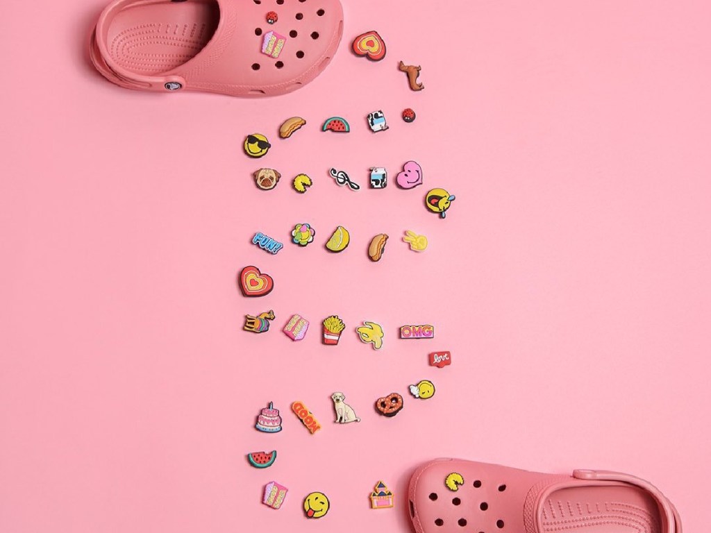 two pink clogs and various charms