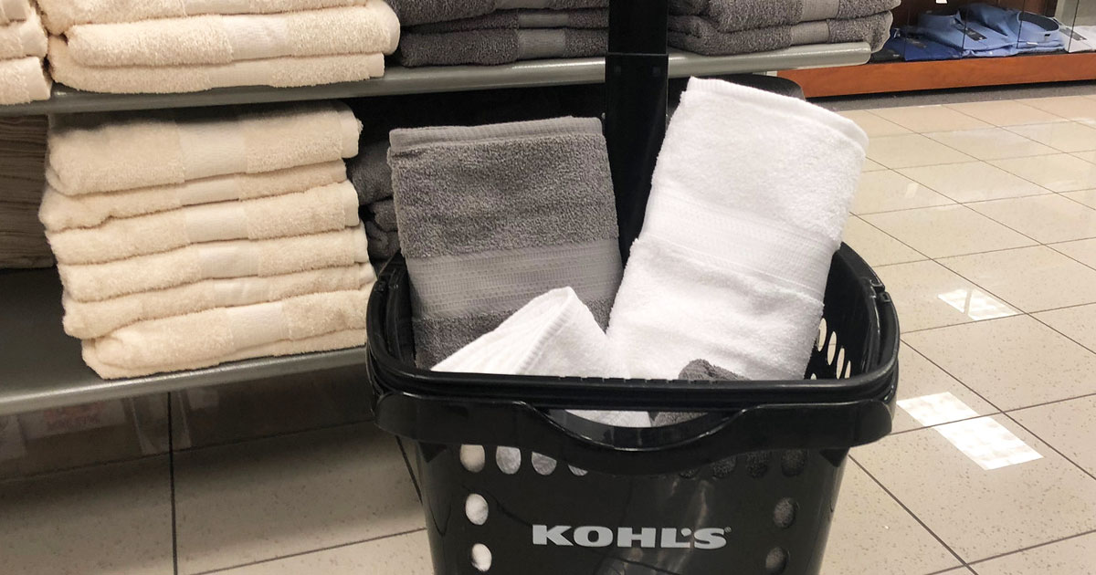 grey and white folded bath towels in a black kohl's shopping basket in front of towel display