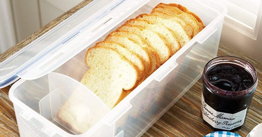 bread box with bread in it and jar of jam next to it