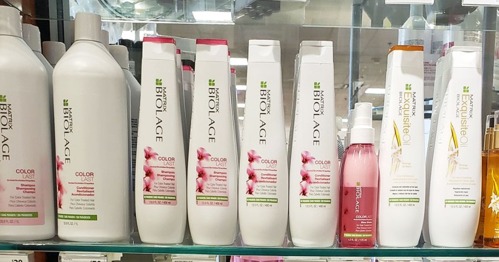 white and pink bottles of martic biolage color last shampoo and conditioner on a glass shelf