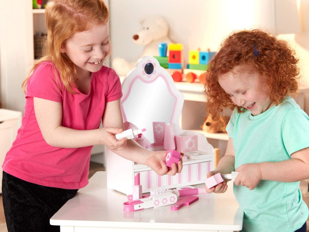 two little girls playing with a melissa and doug beauty salon set 
