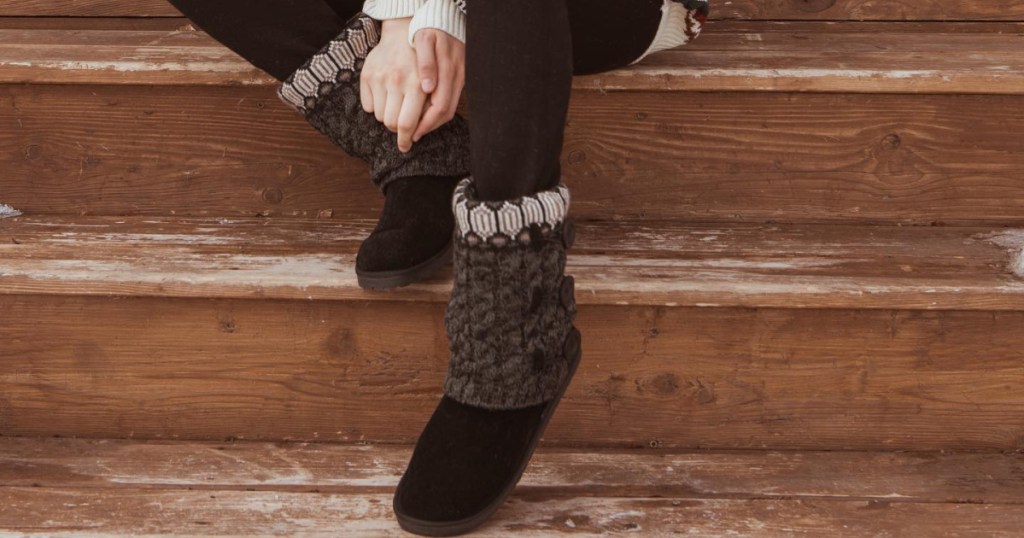 woman wearing brown knit boots sitting on wood steps