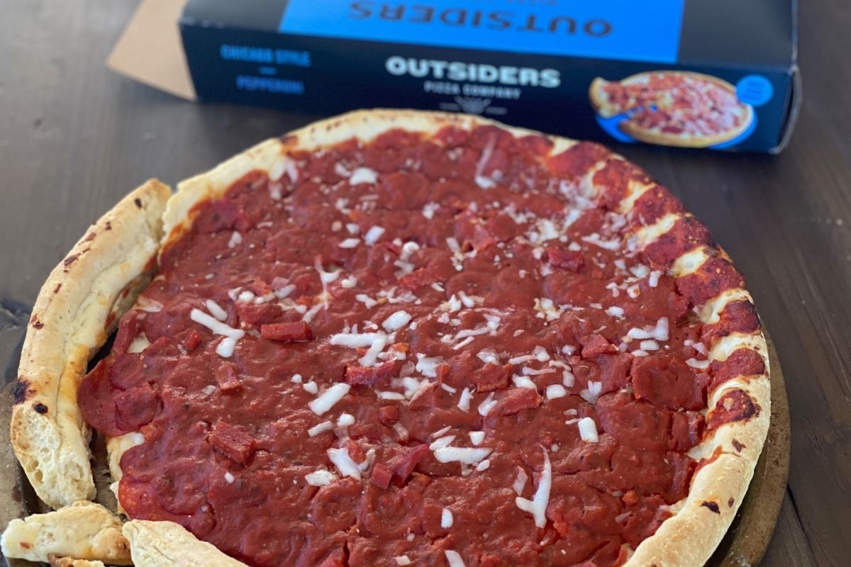 Outsiders pizza on a table next to the box