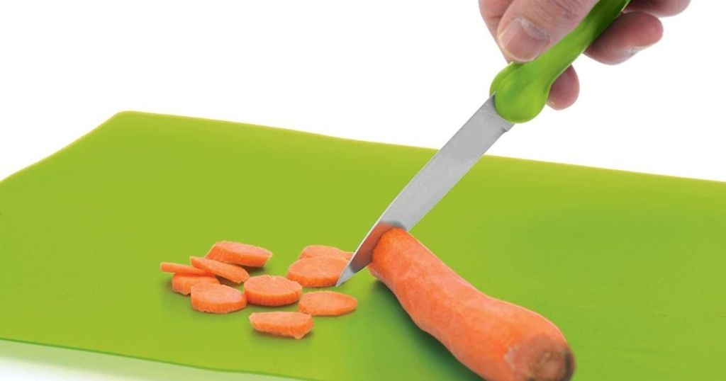 hand cutting a carrot with a knife