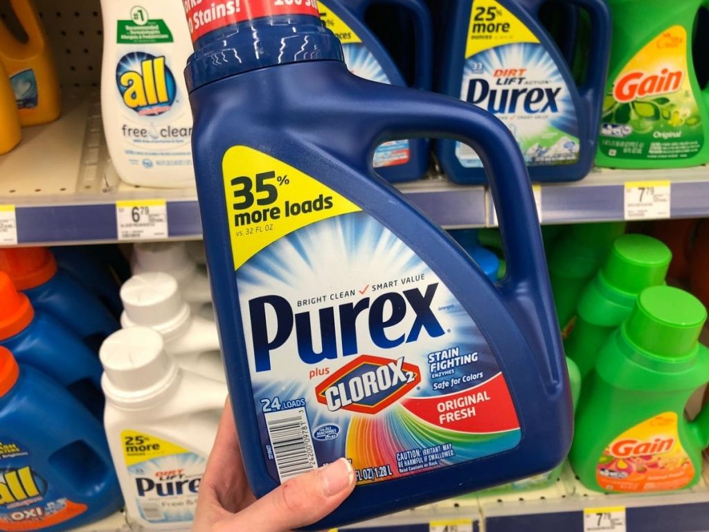 Woman's hand holding up a bottle of Purex Liquid Laundry Detergent