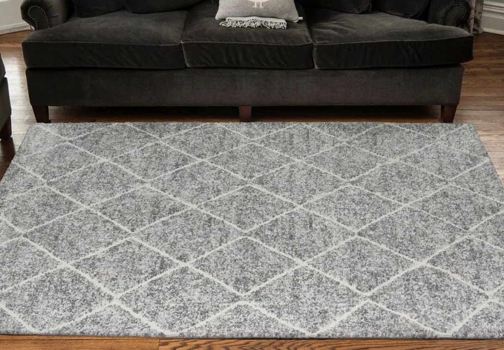 grey and white lattice print rug in front of black couch