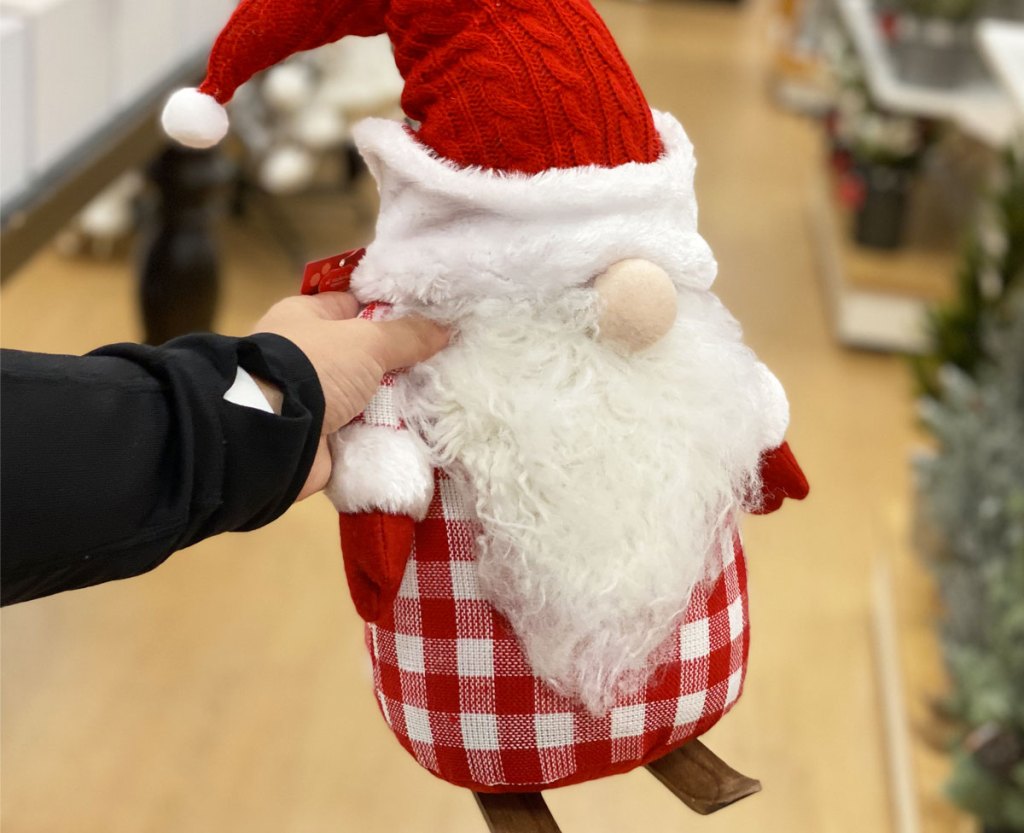 person holding up red and white christmas themed gnome