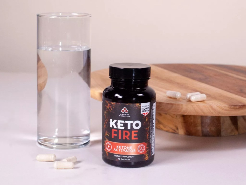 ketofire capsules next to a glass of water