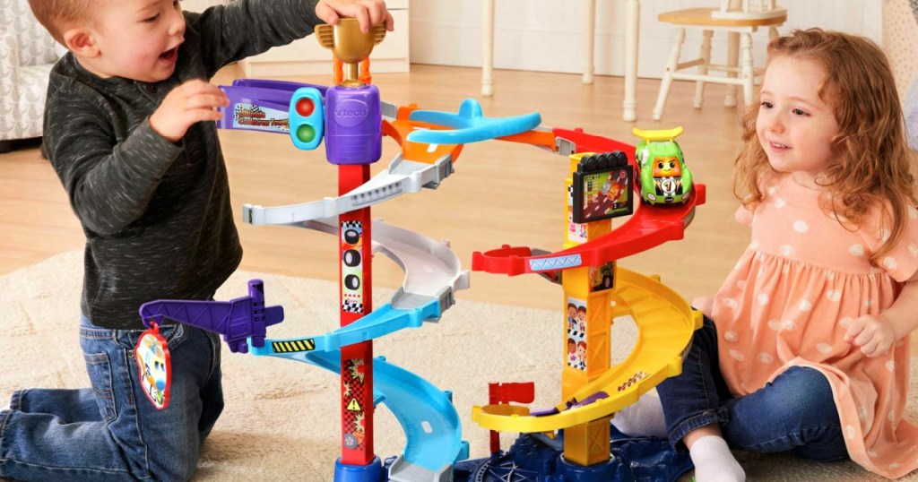 kids playing with a VTech Go! Go! Smart Wheels Ultimate Corkscrew Tower