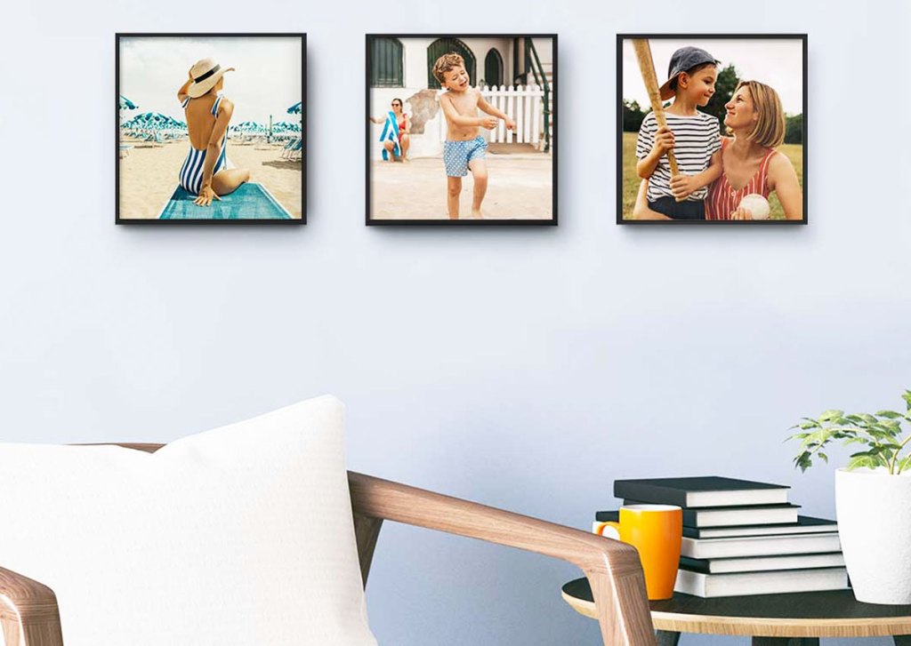 three framed photos on a wall above an accent chair and table