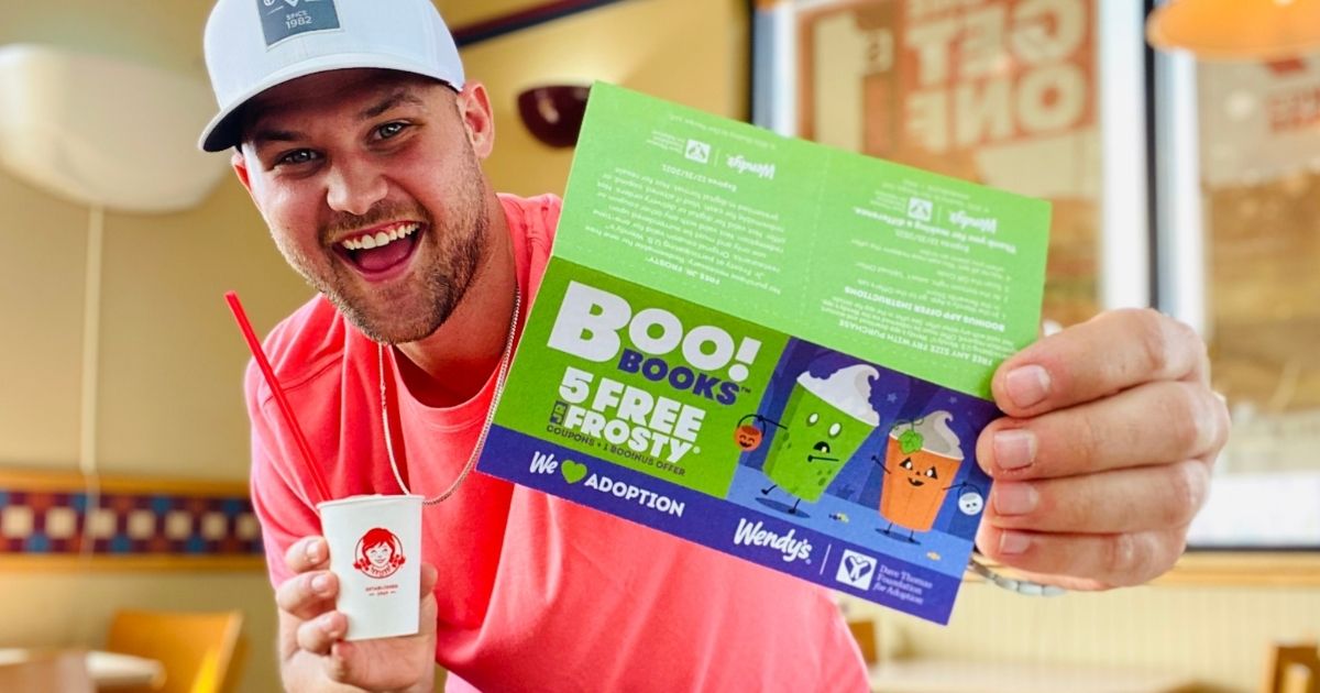 man holding a frosty and a Wendy's boo book