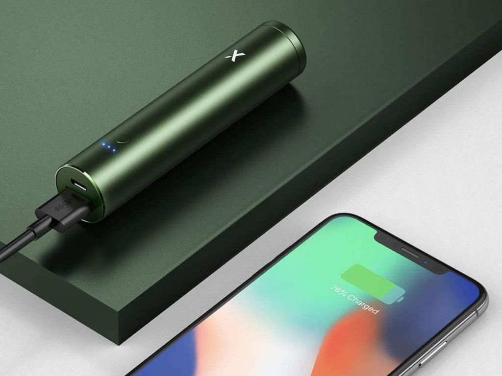green lipstick charger on green surface next to phone