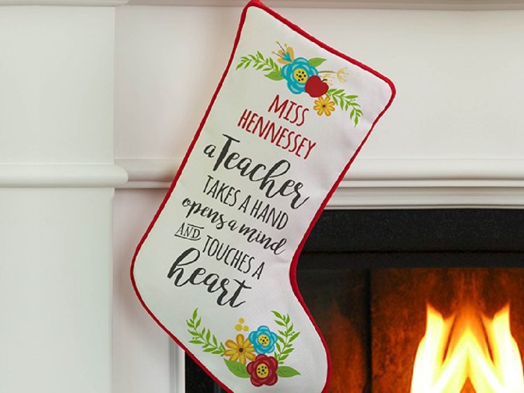 Personalized teacher themed stocking hanging from a fireplace mantle