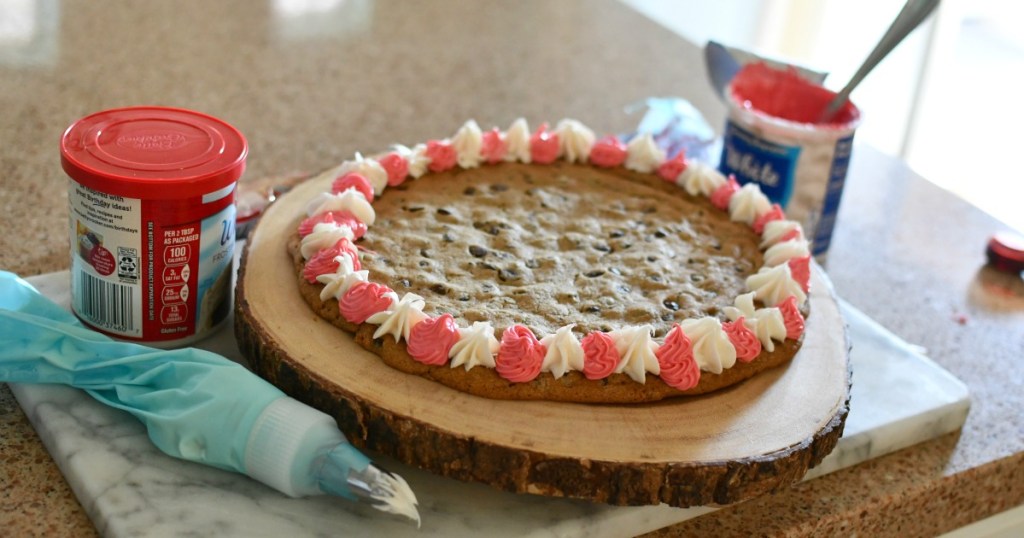 adding frosting all around a cookie cake