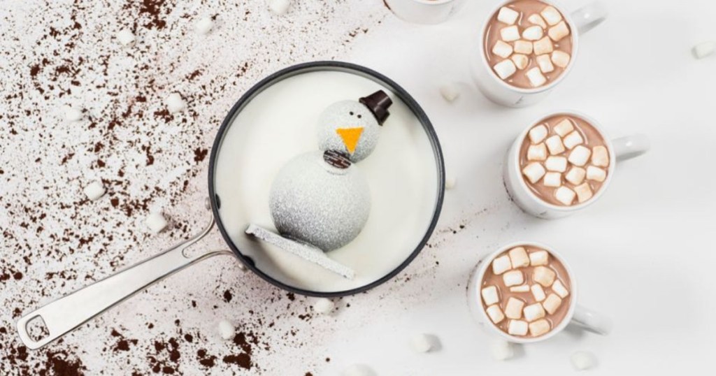 snowman cocoa bomb in pot of milk