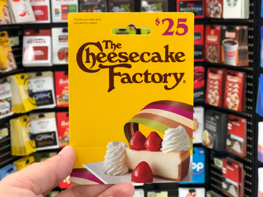 hand holding up gift card by store display