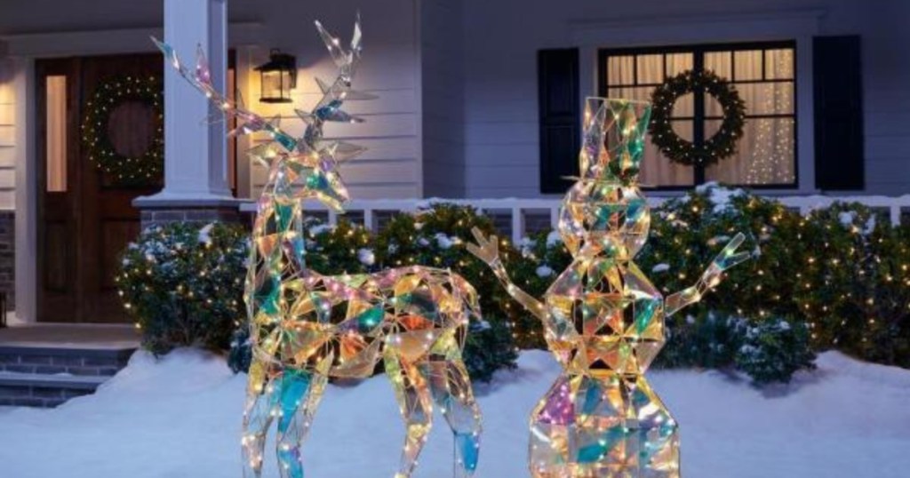 iridescent reindeer and snowman decorations in snowy yard