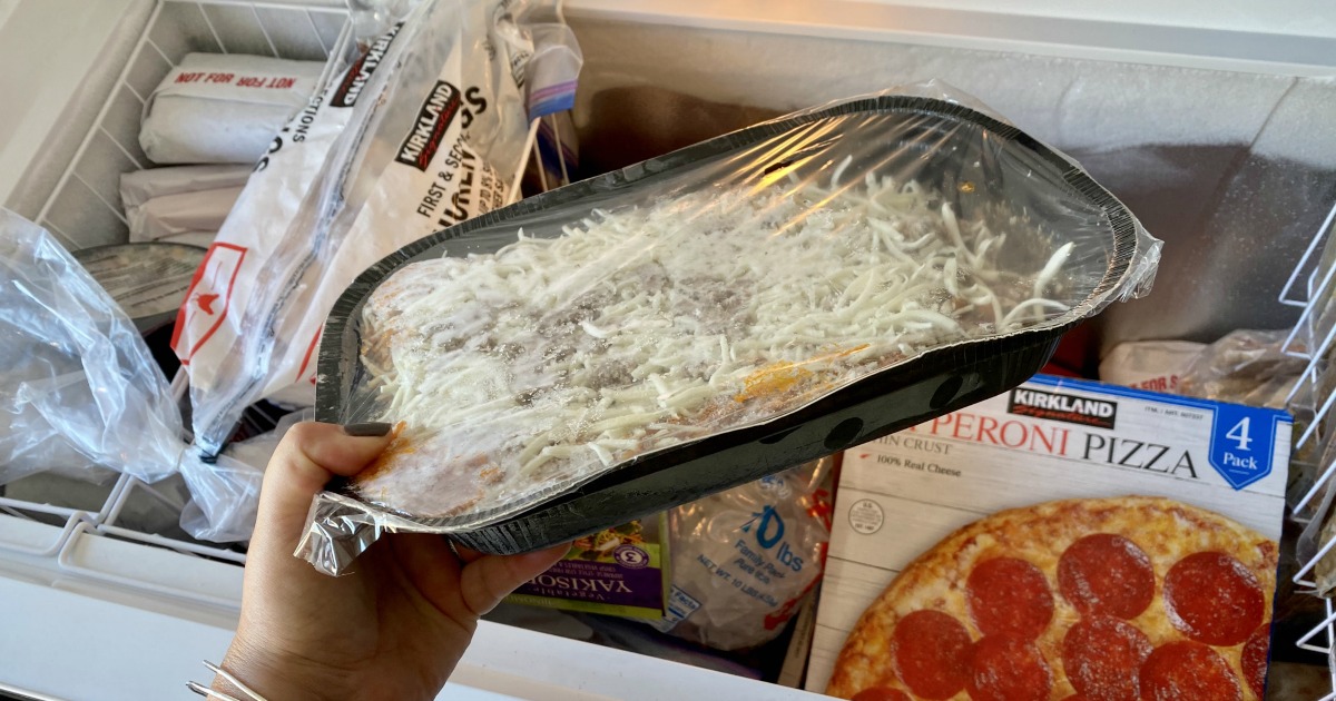 holding a frozen costco lasagna by the freezer
