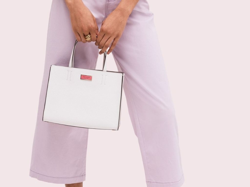 woman carrying white and pink Kate Spade handbag