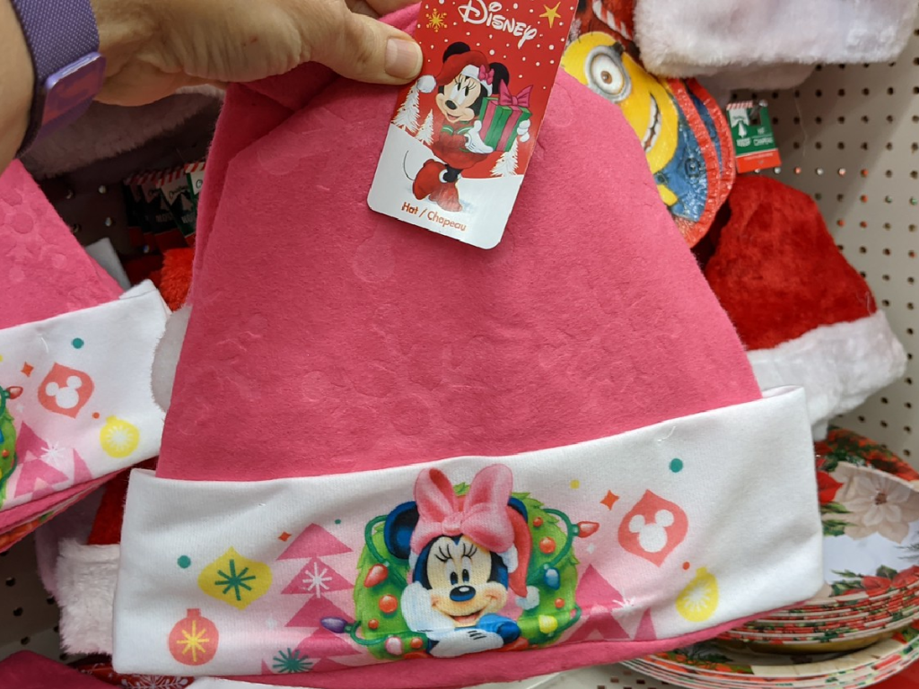 hand holding pink Minnie Mouse hat in store