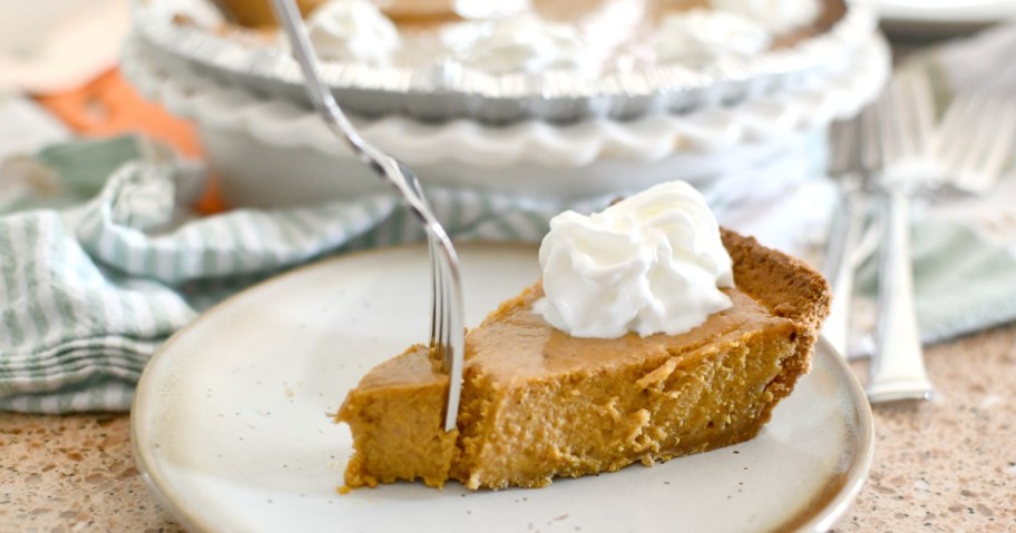 Pumpkin pie on a plate with whipped cream