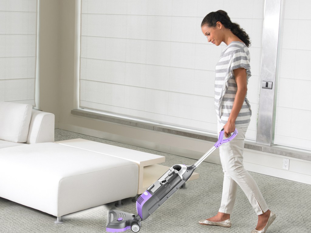 woman vacuuming under her bed