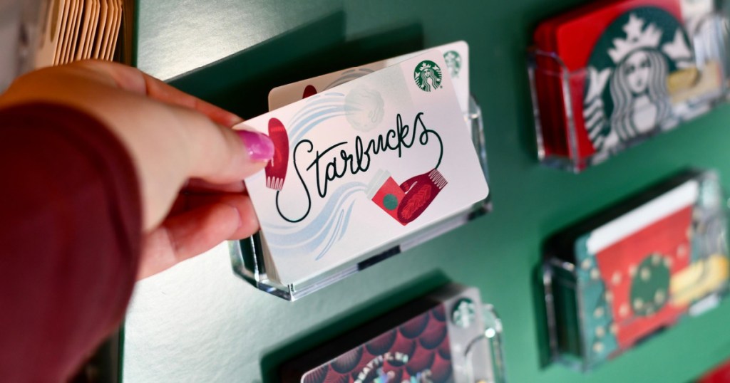 hand grabbing gift card by display for Starbucks