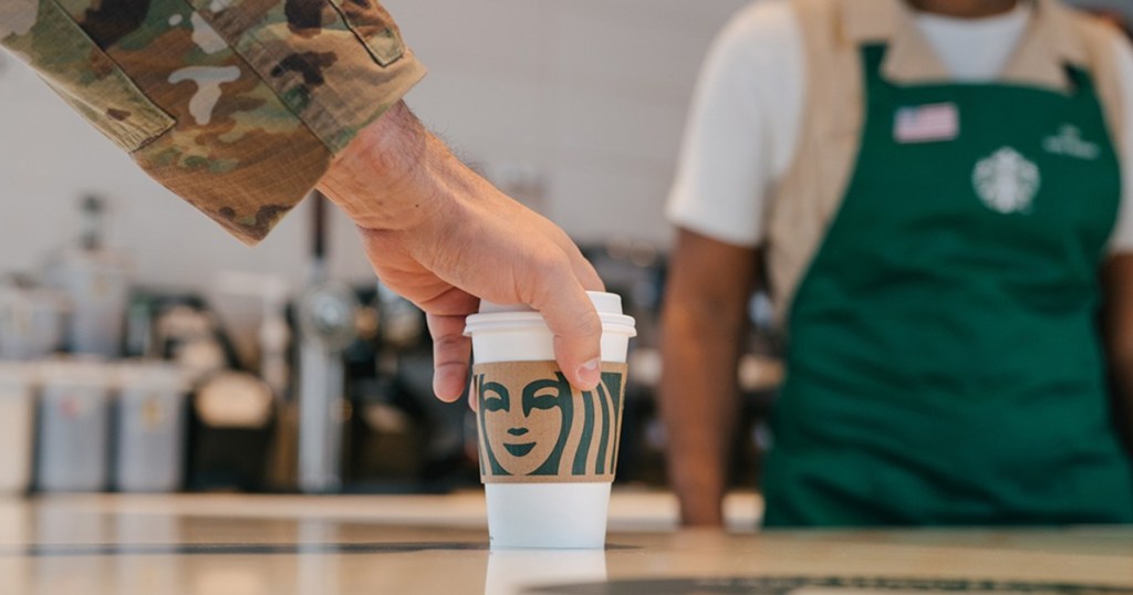 US military service person reaching for Starbucks drink