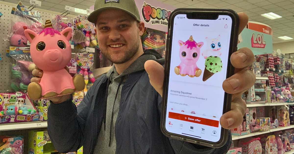 man holding a phone displaying a Target Circle offer in one hand and a pink unicorn toy in the other