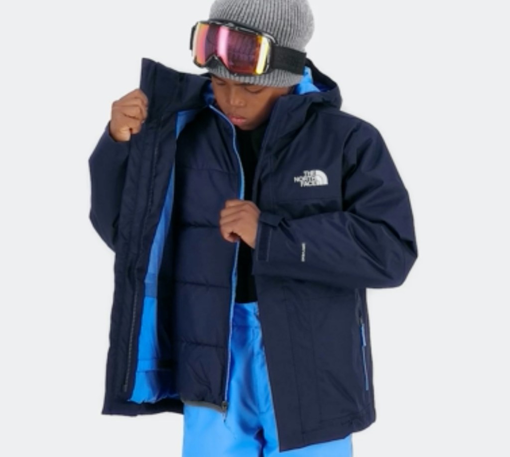 boy wearing winter jacket and ski googles on head