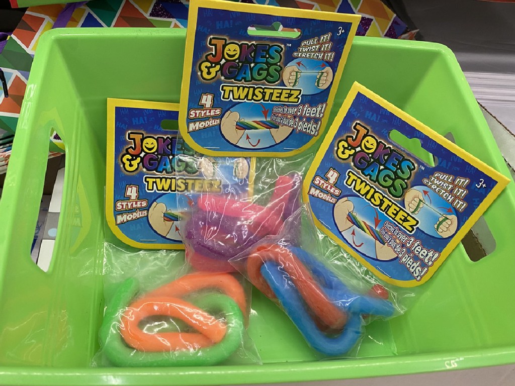 green bucket with three packages of play noodle toys