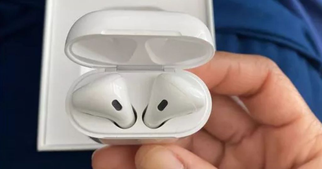 hand holding a pair of airpods