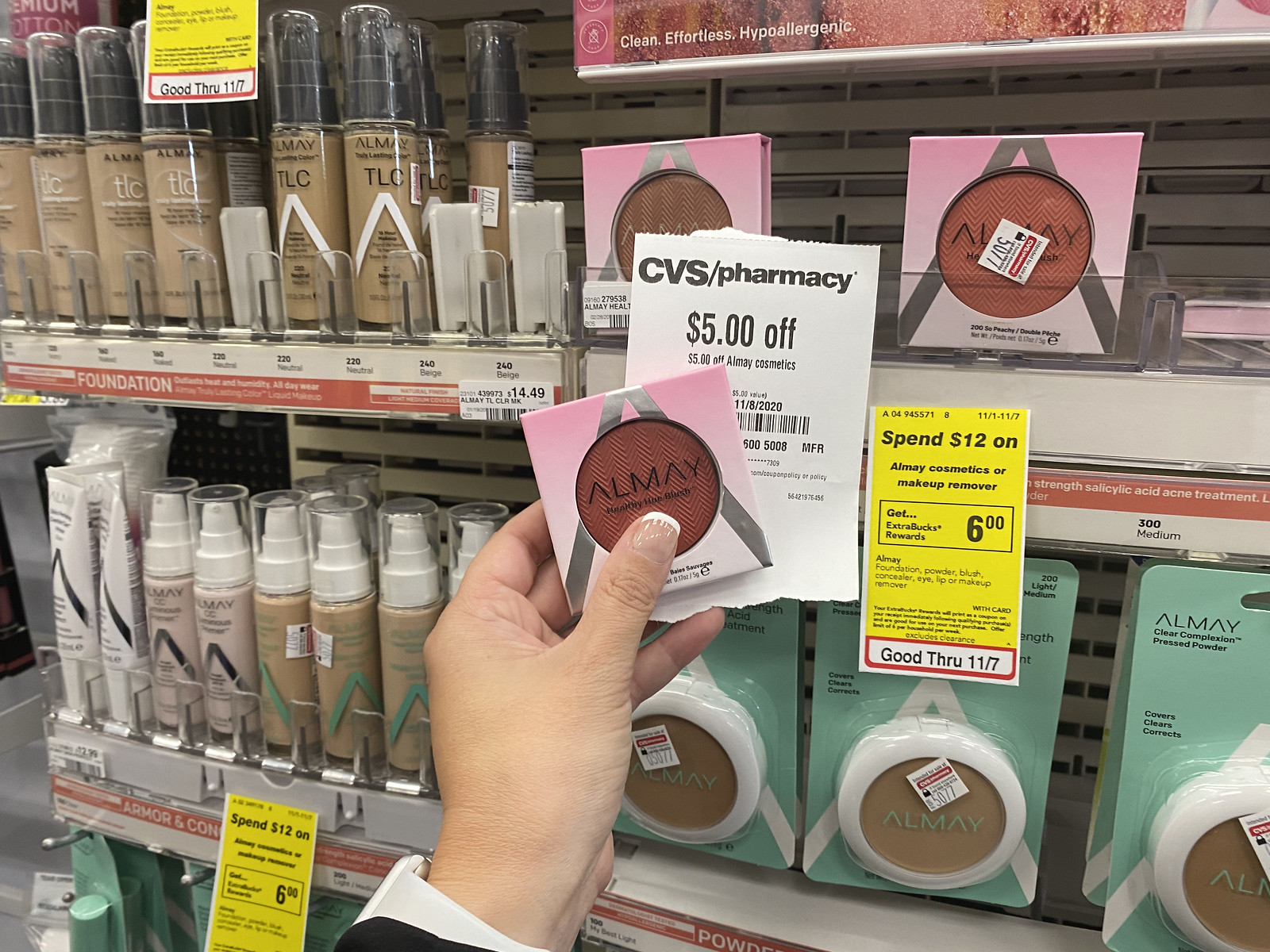hand holding Almay Hue Blush and a CVS coupon in store
