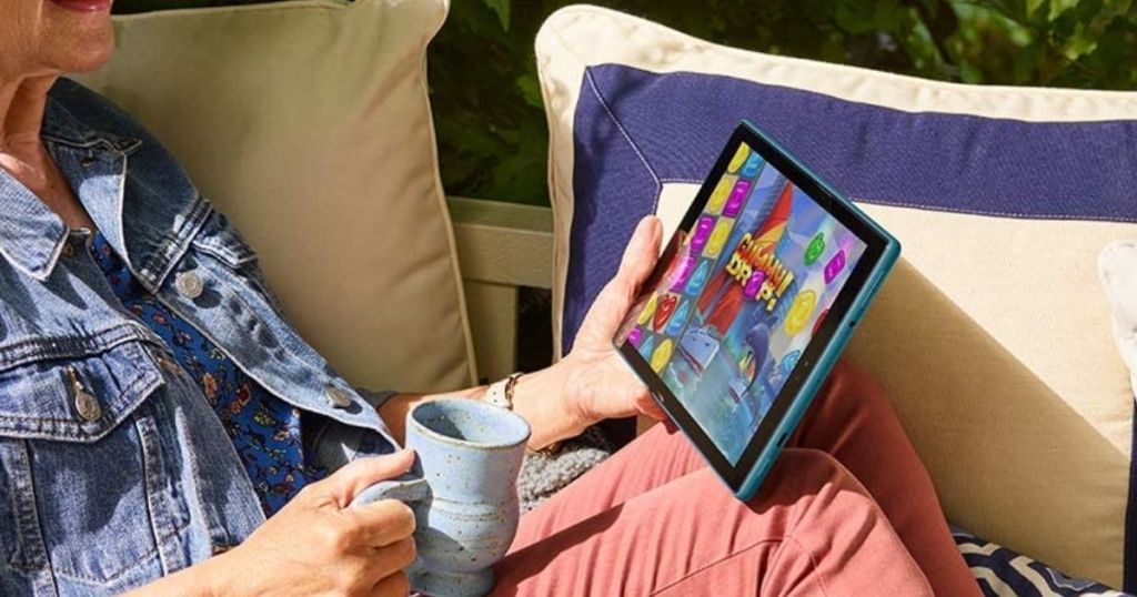 woman reading Amazon Fire HD 10 with a cup of coffee
