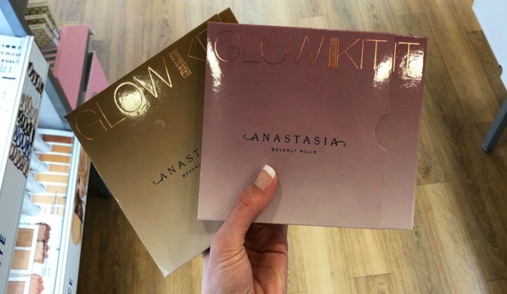 woman holding up two Anastasia Beverly Hills highlighting palettes